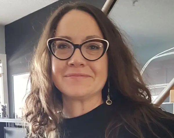 a woman wearing glasses and smiling