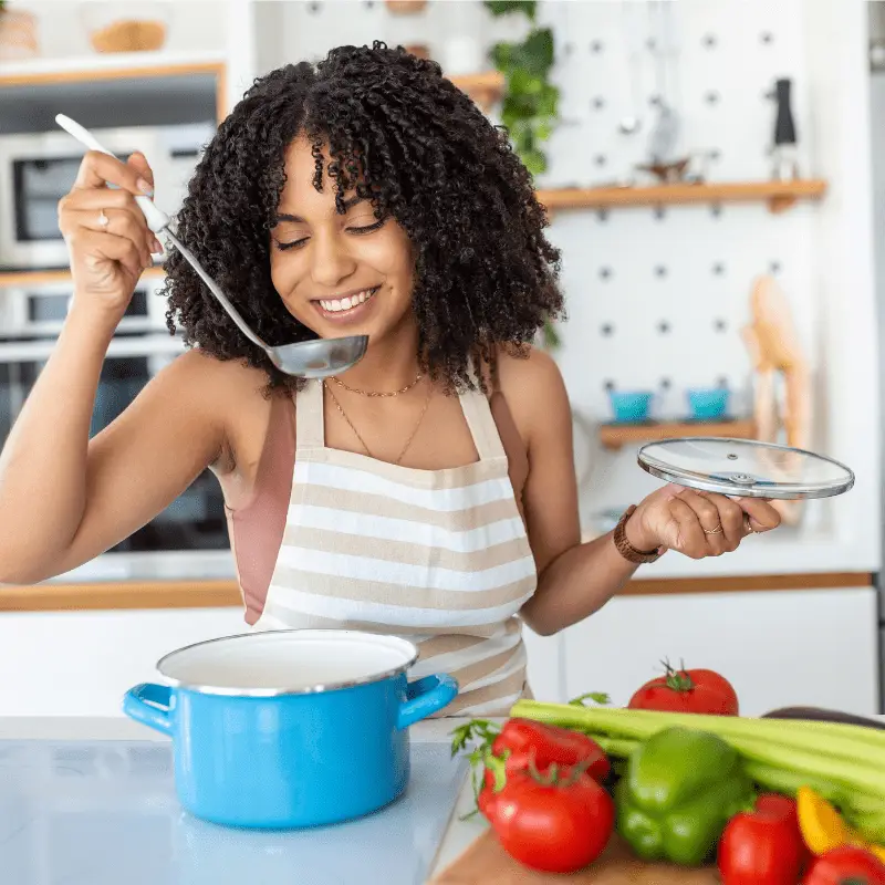 a woman holding a ladle and a pan
